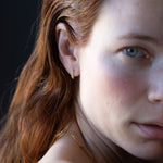 Close-up of Hand-Carved Crooked Fern Huggie Hoops with Sculptural Design