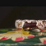 Close-up of No. 85 ring showcasing hand-carved texture and gemstone details