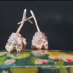 Side view of ROTA II earrings highlighting two-part floral construction