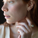 Close-up of hand-carved huggie hoops with champagne diamonds